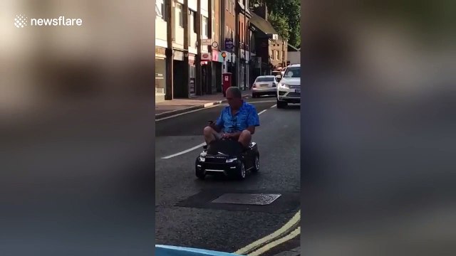 Hilarious moment man drives through UK town in toy car