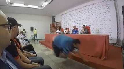 Un homme tente de prendre une photo et tombe en pleine conférence de presse.