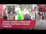 Ayudan a cruzar charcos por 5 pesos en Ecatepec