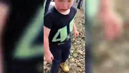 La réaction drôle d'un enfant face à des voitures de course.