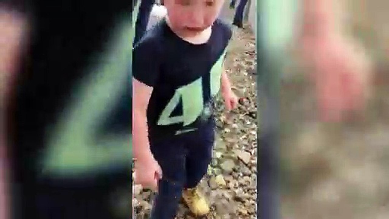 La réaction drôle d'un enfant face à des voitures de course.