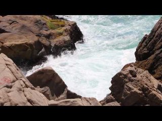 Olas del mar golpeando en las rocas