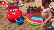 Agréable homme araignée adam déballe jouets voitures sur la plage de côte dazur