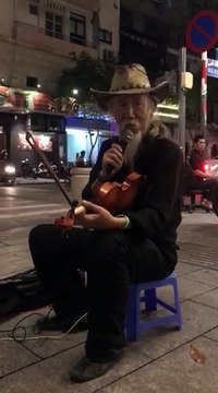 Nghệ sĩ đường phố Trí Hải biểu diễn đàn trên đường phố Sài Gòn
