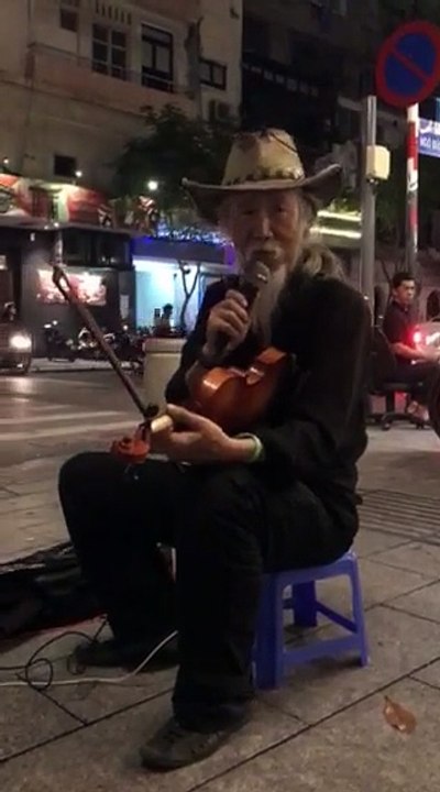 Nghệ sĩ đường phố Trí Hải biểu diễn đàn trên đường phố Sài Gòn