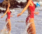 Krupa -ing a feel! Reality star Joanna has her very own Baywatch moment in a perilously plunging caged red swimsuit duri