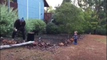 Un petit garçon trouve son papa très drôle pendant qu'il couple du bois !