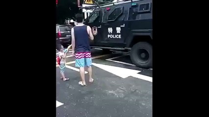 Descargar video: Un enfant joue avec un policer caché dans un blindé au pistolet à eau !