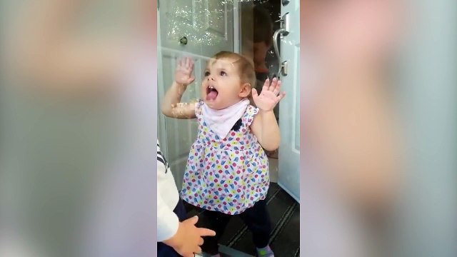 Cette petite fille adore faire des grimaces à travers la vitre !