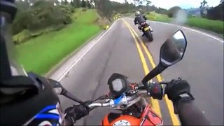 Un cycliste double deux motos en pleine descente