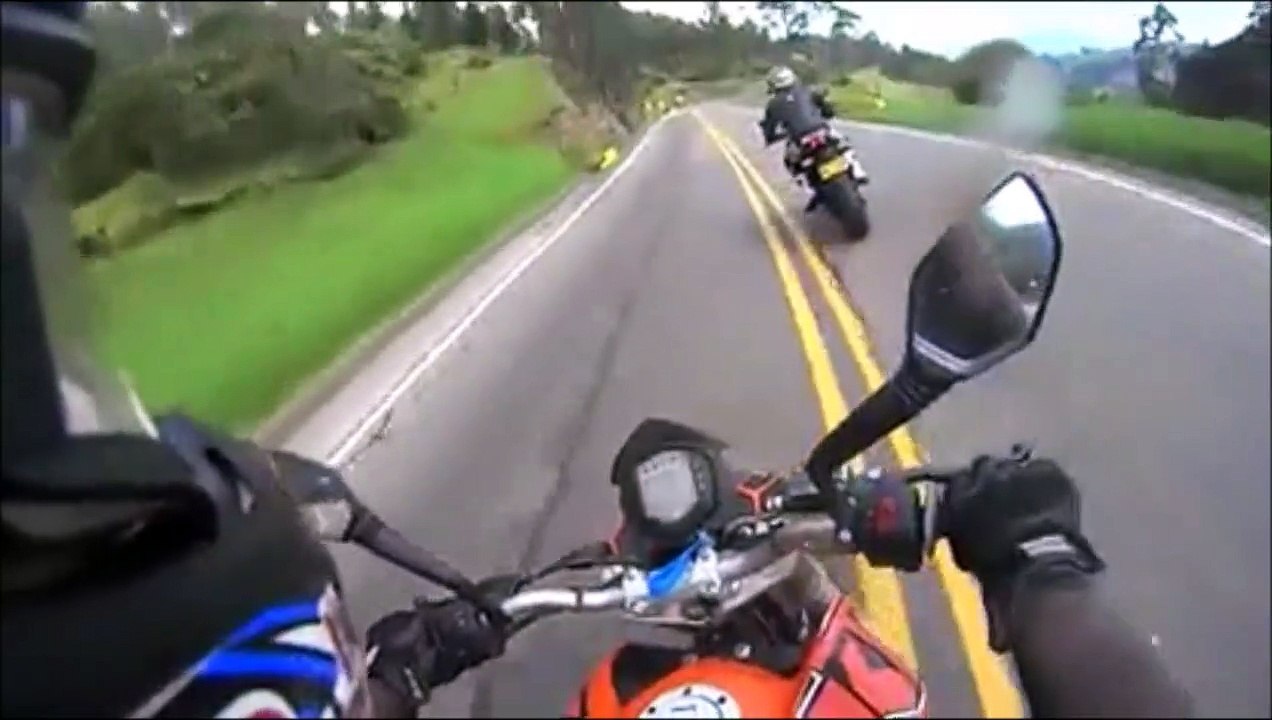 Un cycliste double deux motos en pleine descente