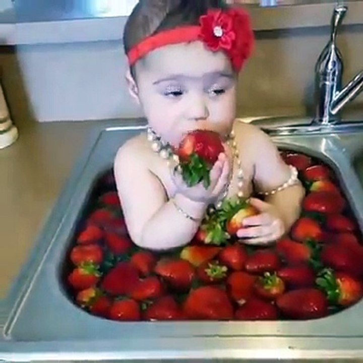 Cute baby girl eating strawberry