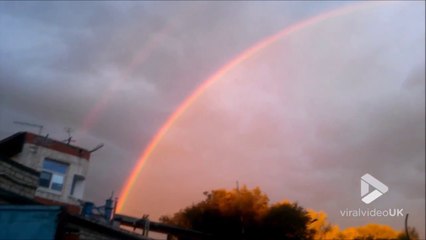 Ce mécano admire un arc-en-ciel magnifique