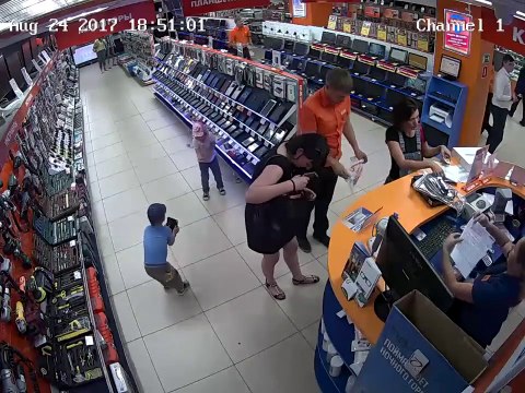 2 gamins volent un iPad relié à un cable de sécurité sous les yeux d'n vendeur