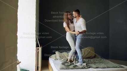 Download Video: Young beautiful and loving couple dancing and kissing on bed in morning