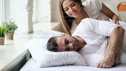 Young beautiful and loving couple wake up at the morning. Attractive woman kiss and hug his husband