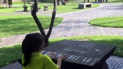 Girl practices piano on table with chalked keyboard