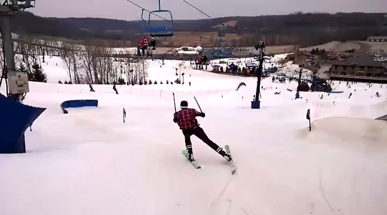 Un skieur fait un saut à ski et un High Five avec une personne sur un télésiège