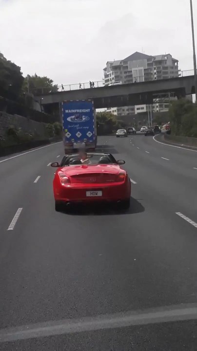 Ces parents inconscients laissent leur enfant debout à l'arrière de leur voiture décapotable..