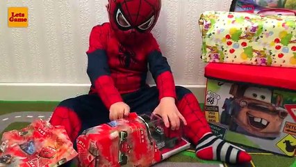 Homme araignée petit garçon déballage et joue avec jouet voiture