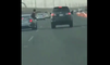 Un jeune homme côté passager sort par la fenêtre alors que le conducteur est en plein excès de vitesse.