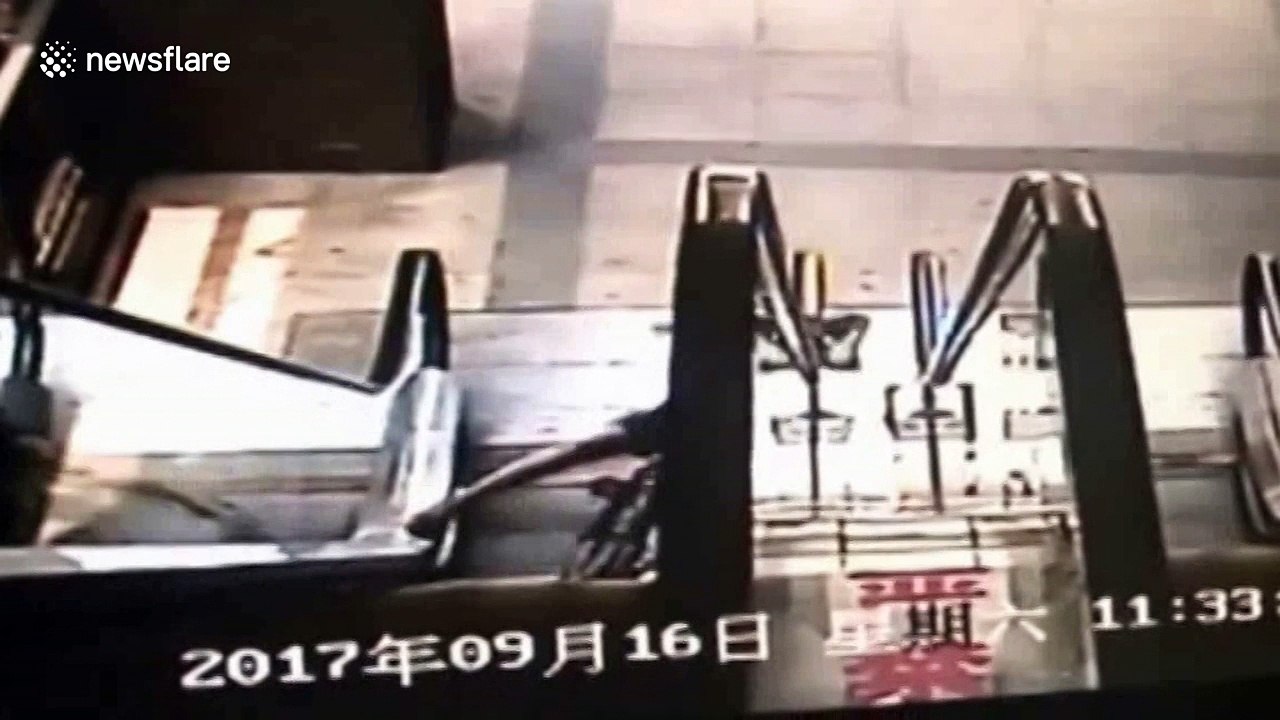 Boy on bike falls down escalator
