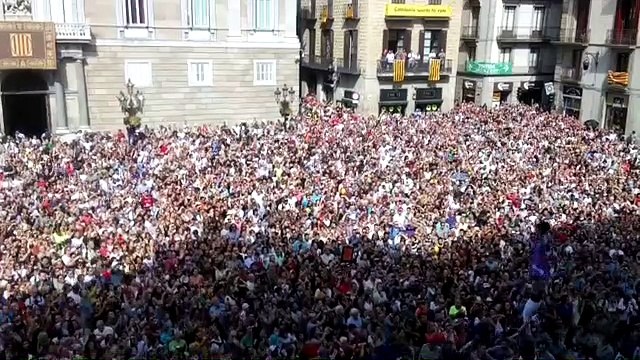 Castellers entren a la plaça de Sant Jaume de Barcelona amb una pancarta que diu 'Democràcia'