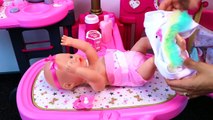 Cute little girl playing with Baby doll nursery station - baby bath time, diaper change, feeding