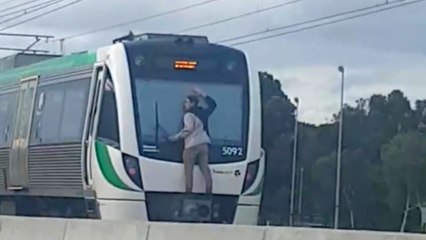 Un jeune accroché à l'arrière d'un train pendant qu'il roule