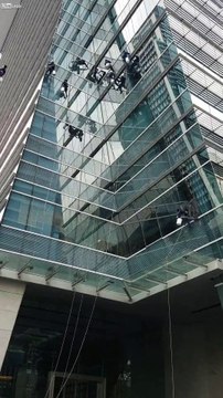 Laveurs de vitres d'un gratte-ciel suspendus à des cordes à Bangkok en Thaïlande !