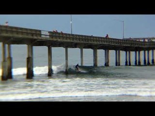 Daredevils Bravely Try to Surf Below Pier