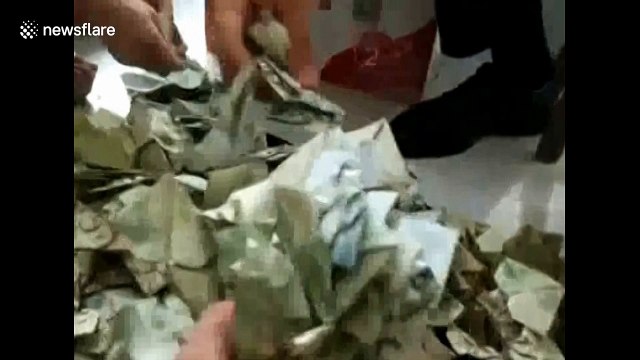 Couple buy car with bag of origami hearts made out of banknotes