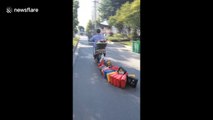 Woman drags dozens of jerry cans at the back of her scooter