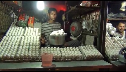 Man cooking Egg Omelette and giving it to customer on bread.