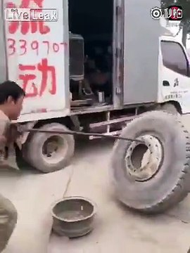 One armed man works as mechanic at truck garage