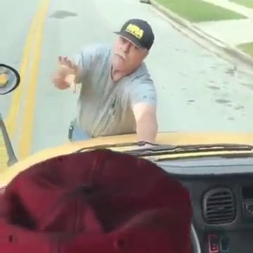 Ce fou s'accroche à l'avant du bus scolaire en marche sous prétexte de vouloir rentrer dedans !