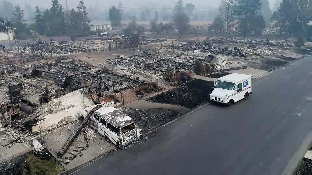 Un facteur distribue le courrier au milieu des maisons brulées (Santa Rosa)
