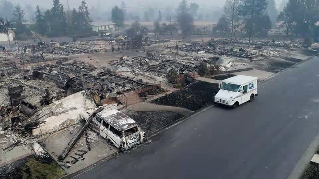 Un facteur distribue le courrier au milieu des maisons brulées (Santa Rosa)