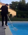 Un père de famille en costume poussé par son fils dans une piscine
