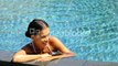 bikini-woman-lying-relaxing-in-infinity-pool-at-luxury-resort-spa-retreat-beautiful-mixed-race-woman