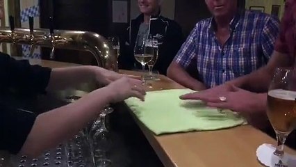 Un homme fait un petit tour de magie à la serveuse d’un bar
