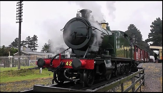 Englische Dampflokomotive verlässt den Bahnhof mit einem Güterzug