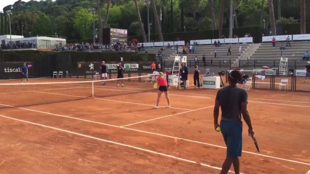 Gaël Monfils smash en sautant au-dessus de sa partenaire à l'entraînement