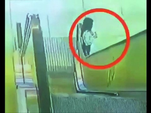 Child's shirt gets trapped in an escalator's belt, gets dragged up