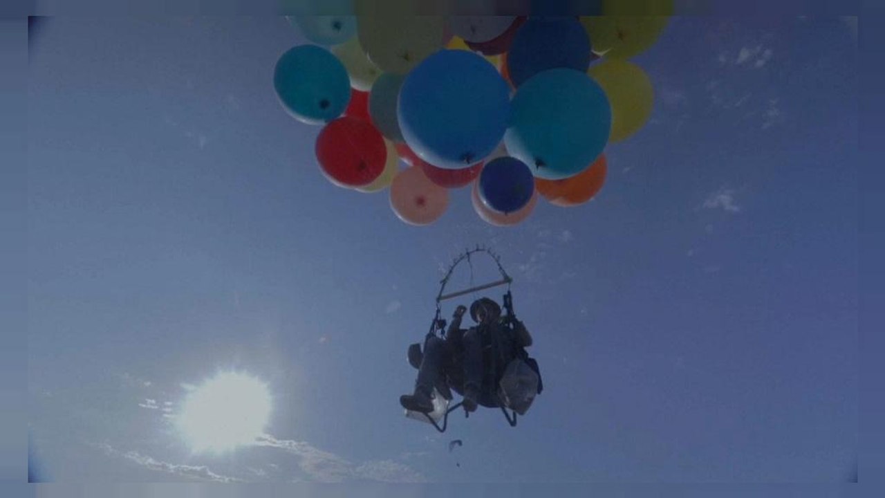 Accroché à des ballons gonflés à l'hélium