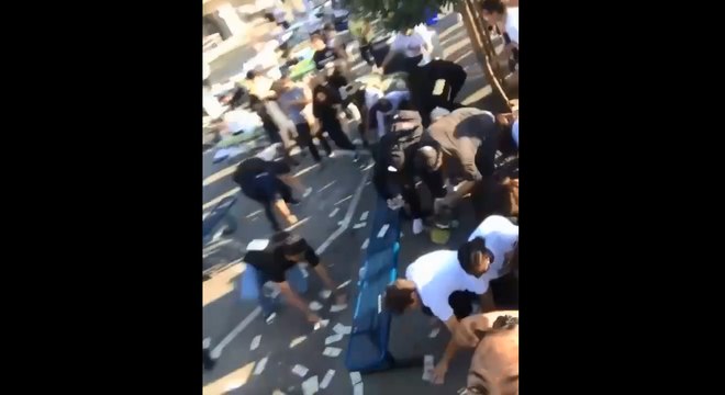 Un rappeur balance une liasse de billets dans une cours d'école.