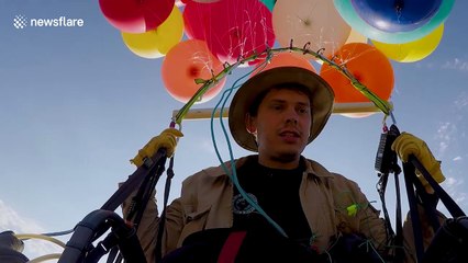 The moment a thrill-seeker floated from 100 helium balloons above South Africa