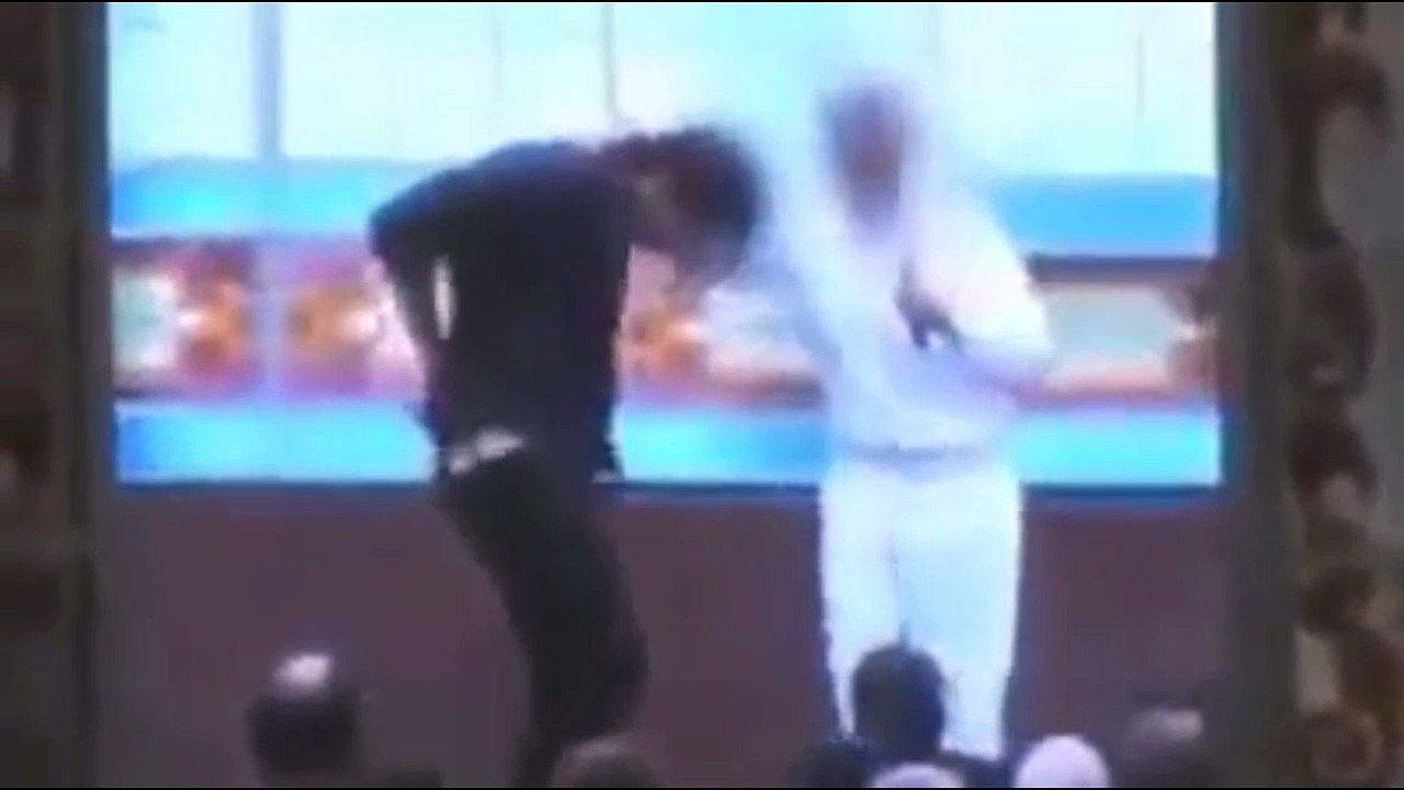 Pasteur essaie de prendre le «démon» du jeune homme qui révèle la farce et commence à chanter et à danser