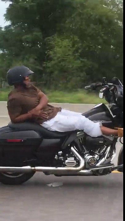 Un motard allongé sur sa Harley-Davidson