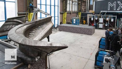 Industrial robots weave a metal bridge as they move in mid-air